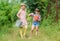 Rustic children nature background. Agriculture concept. Girls in hats planting plants. Sisters helping at farm. Family