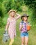 Rustic children nature background. Planting and watering. Agriculture concept. Girls in hats planting plants. Sisters