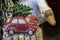Rustic Christmas decor - glittery red miniature cars with Christmas trees on top sit on bird twigs with blurred stuffed goose and