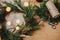 Rustic Christmas wreath. Fir branches, pine cones, thread, berries, scissors and golden lights bokeh on wooden table. Christmas