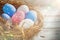 Rustic Colorful Eggs in the Hay Nest on the Wooden Background