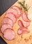 Rustic composition with a smoked, dry Krakowska sausage. Traditional Polish meat cold cuts.