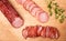 Rustic composition with a smoked, dry Krakowska sausage. Traditional Polish meat cold cuts.