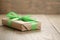 Rustic craft paper gift box with green ribbon bow on wood table