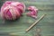 Rustic crochet thread and a bamboo hook. Warm pink winter yarn ball for knitting and crochet on the wooden table. Rustic backgroun