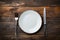 Rustic dining style Empty plate, fork, knife on gray wood