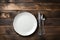 Rustic dining style Empty plate, fork, knife on gray wood