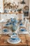 Rustic dining table set with blue glassware and floral centerpiece