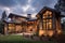 rustic exterior with stone accents, metal roof and modern exterior lighting