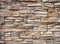 Rustic exterior stone wall made of natural brown stone. Masonry work