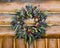 Rustic Fall Wreath Hung From a Log Cabin Structure