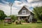 Rustic farm in rural area with solar panels and windmill. Renewable energy concept.