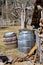 Rustic farmyard scene with two old barrels and a woodpile