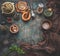 Rustic food background with vintage kitchen utensils. Herbs and spices in wooden bowls, olives oil and napkin. Frame. Top view.
