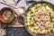 Rustic food. Dish with stewed mincemeat ,cabbage, rice and mushrooms with cooking spoons on dark vintage background