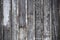 Rustic grey worn board and batten vertical siding background with white paint remnants