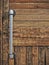 Rustic hand-crafted wooden door with metal plumbing pipe as handle
