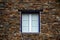 Rustic hand-hewn wood window set into a stone wall built from schist in PiodÃ£o, made of shale rocks stack, one of Portugal\'s