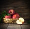 Rustic healthy red apples in a bascket on wooden background