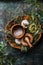 Rustic herbs and spices in wooden bowls on dark background. Top view. Rural cooking utensils