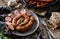 Rustic or homemade sausage on plate with fresh parsley, spices, whole bread on wooden background. Meat appetizer, set of wine,