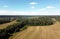 Rustic landscape with summer fields with many rolled haystacks and forests on horizon bird view