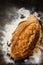 Rustic loaf of bread and flour on black chalkboard from above