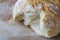 Rustic loaf of homemade bread close up on wooden board. Broken bread overhead view