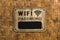 A rustic looking Wifi sign with a blank area to write password on a rattan wall at a restaurant