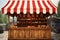 A rustic market stall with a traditional red white striped canopy