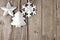 Rustic metal Christmas ornaments hanging on aged wood