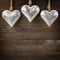 Rustic metal heart ornaments hanging on wood