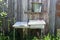 Rustic metal washstand with a sink stands on the green grass near a wooden fence in the summer