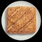 Rustic Multigrain Bread Loaf on White Ceramic Platter Isolated on Black Background