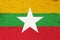 A rustic old Myanmar flag on weathered wood