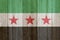 A rustic old Syrian flag on weathered wood