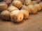 Rustic organic potatoes. Vegetables from farmhouse field is lying in bulk on wooden boards. Heap of potatoes, roots with