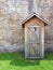 Rustic outhouse in front of vintage stone wall