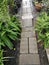 Rustic pathway in the garden, cement brick blocks as footpath to go through the garden in vintage style, simply way.
