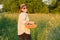 Rustic portrait of mature woman with basket of eggs at meadow, golden hour