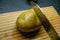 Rustic potato on a wooden chopping board with silver stainless steal knife for cutting