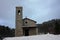 Rustic provincial stone church in the cold of the white snow in the mountains