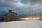 Rustic provincial stone church in the cold of the white snow in the mountains