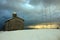 Rustic provincial stone church in the cold of the white snow in the mountains