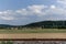 Rustic rail, green meadow, small village hill and cloudy blue sky. Colorful landscape near Tubingen, Germany