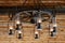 Rustic ranch chandelier made from wood wagon wheel, iron horseshoes, and lanterns, hanging from aged wood ceiling