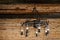 Rustic ranch chandelier made from wood wagon wheel, iron horseshoes, and lanterns, hanging from aged wood ceiling