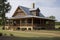 rustic ranch house with wrap-around porch and rocking chairs