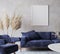 Rustic room design with dark blue sofa and dried flowers on gray interior background