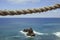 Rustic rope isolated with a rock and sea in the background